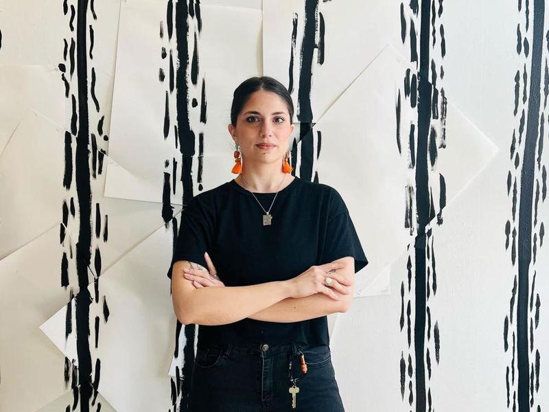 Person standing in front of white wall with black lines