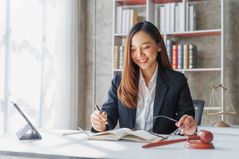 woman sitting at desk with a book and pen