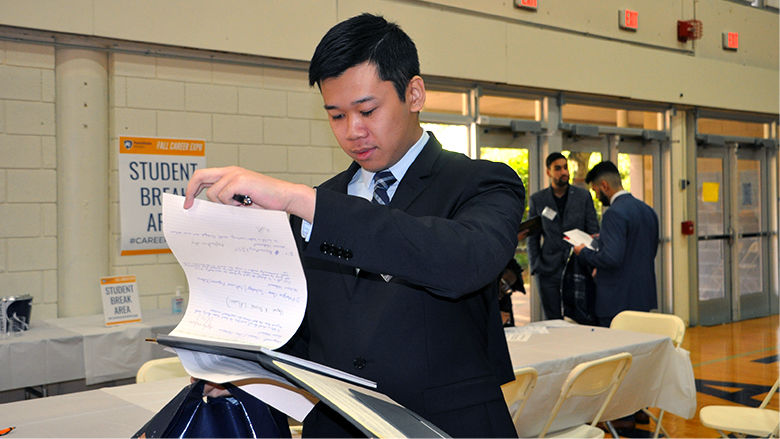 Student looking a papers on clipboard