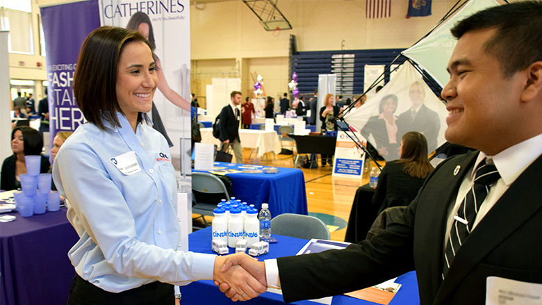 Student and Employer shaking hands at career fair