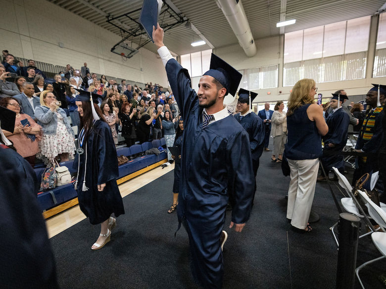 Student at graduation waving