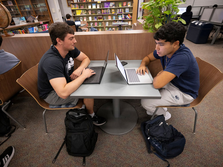 two students with their laptops at a table in the Penn State Abington library near Philadelphia
