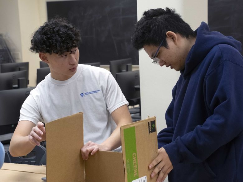 students working on cardboard boat