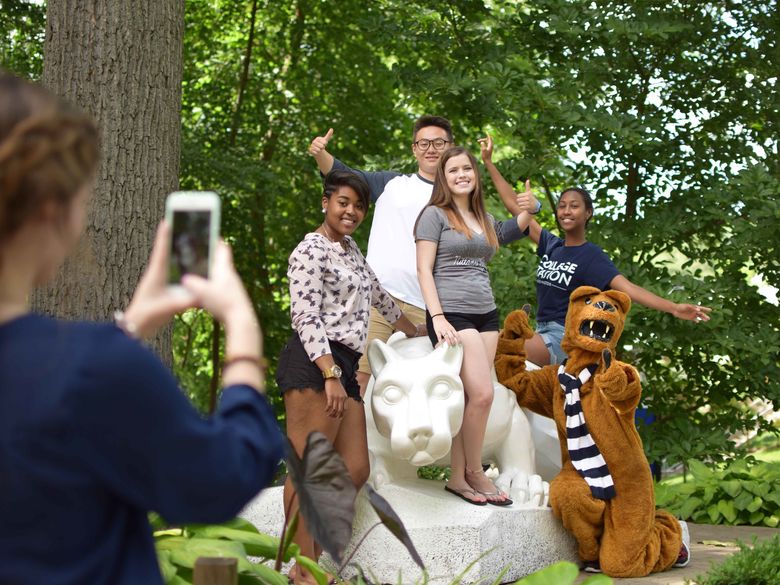 Students pose for a photo by the Lion Shrine