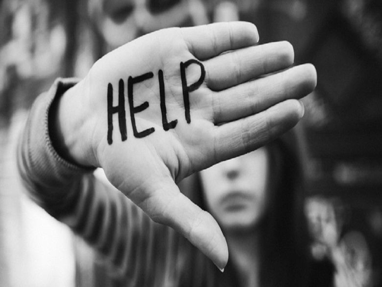 hand held up with the word "help" written on it