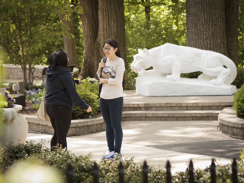 students talking in front of Lion Shrine