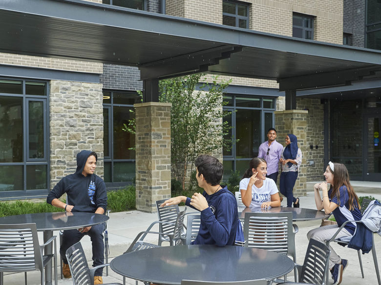 Students sitting outside of Lions Gate on Patio