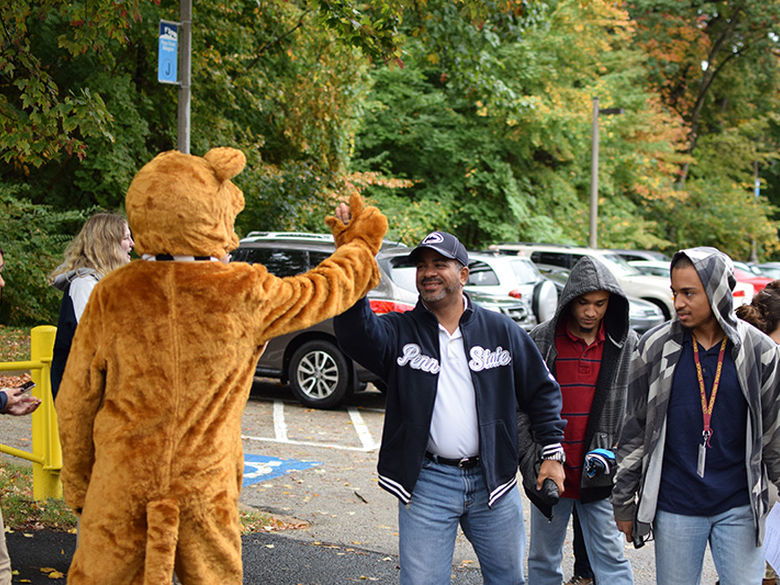 Nittany Lion high-fiving an adult