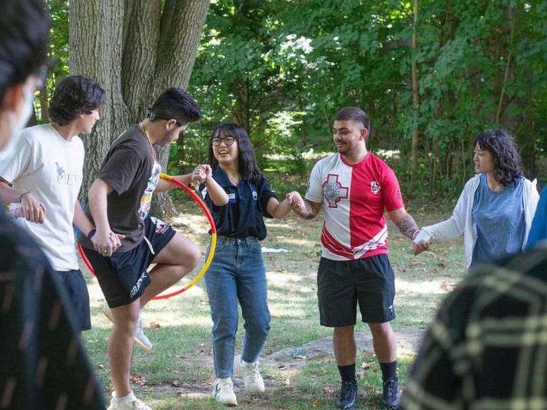 Student holding hands and passing hula hoop 