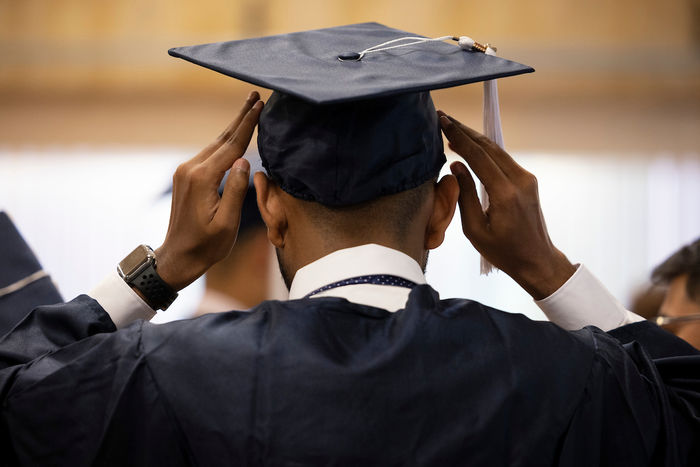 Graduation cap being put on 