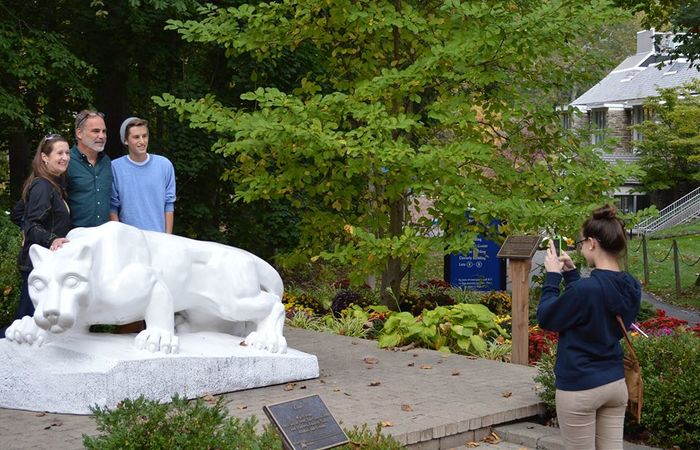 family taking photos at the lion shrine