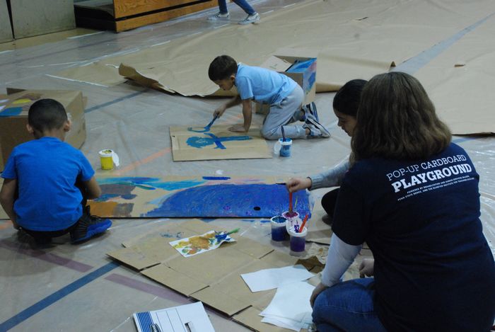 Children painting on cardboard