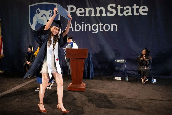 student holding her diploma in the air