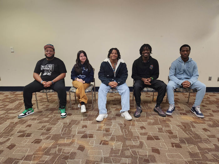 5 students sitting in chairs 