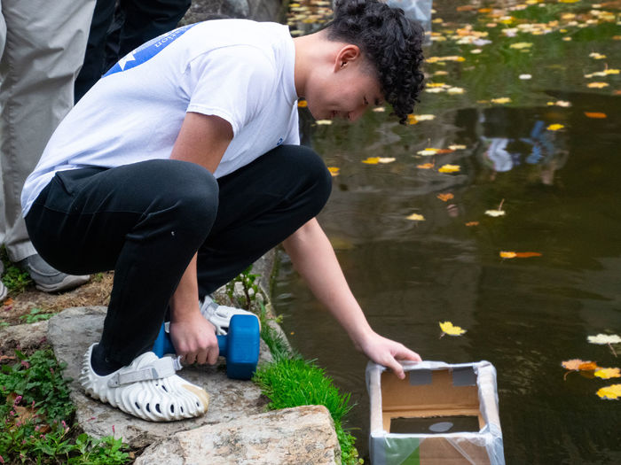 Student testing a prototype boat for the Cardboard Regatta