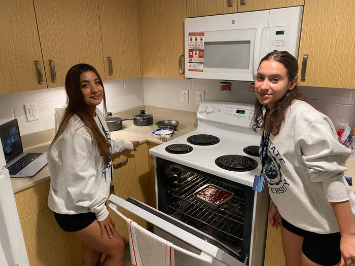 Two students cooking brownies at Lions Gate