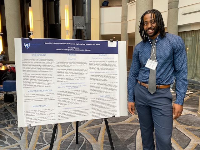 PSS major student standing in front of poster board project 