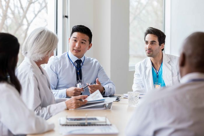 student and doctors talking at a table