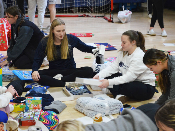 Penn State Abington student athletes wrap gifts for a family in need