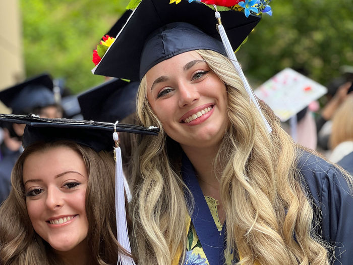 Two women after receiving their college diplomas