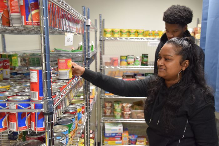 student placing can on shelf