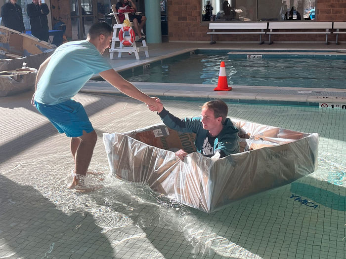 Students launching a boat at the Cardboard Regatta.