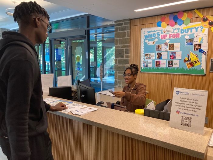 Student working front desk at Lions Gate