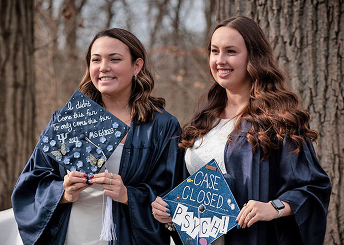 two female graduates  in cap and gown