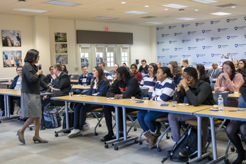 Woman with microphone speaks to classroom full of students