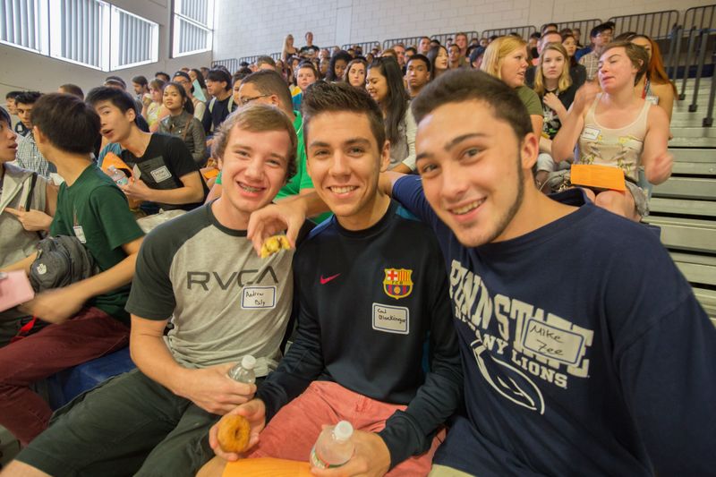three students in crowd in gymnasium
