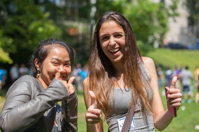 two female students giving thumbs up