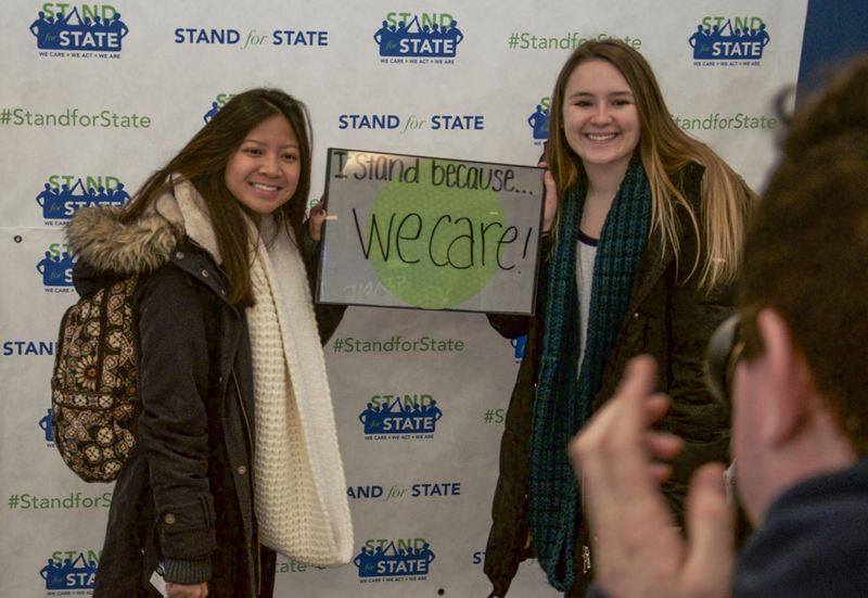 Two students posing with a sign 