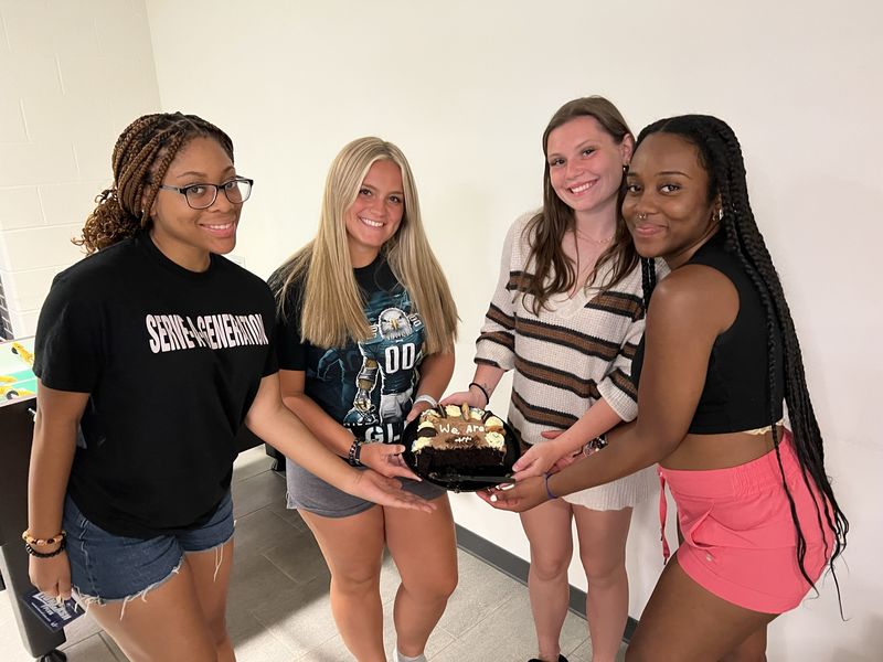 Students holding dessert and smiling