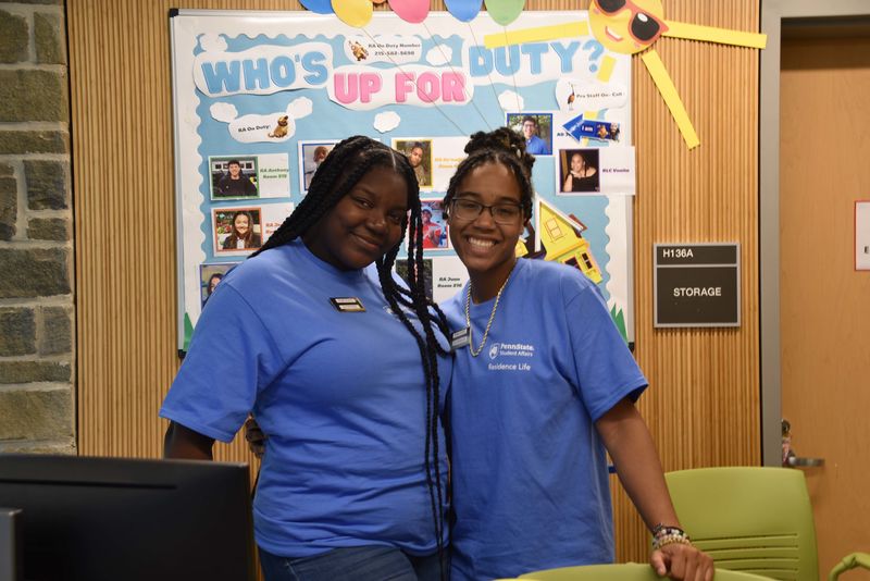 Two students smiling at the front desk of lions gate