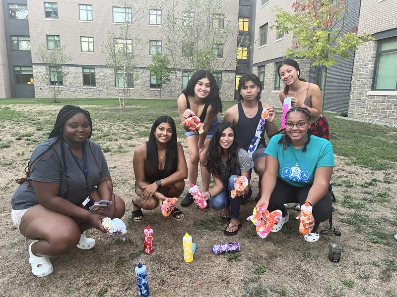 students holding tie dye t shirts