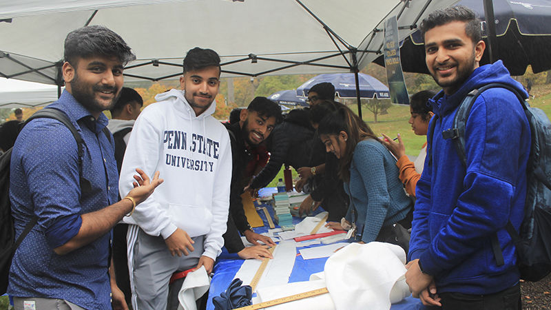 three students under the tent