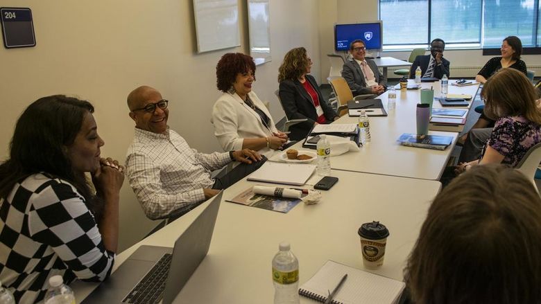 A team from Penn State Harrisburg talks while sitting around a large conference table