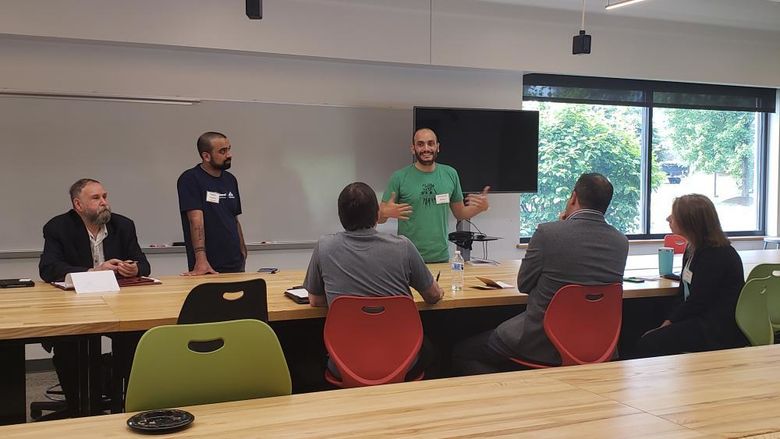 People sitting and standing around a table while talking