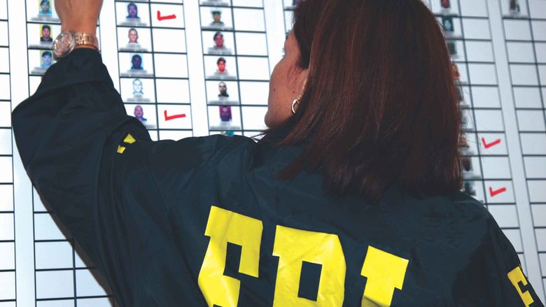 person with FBI jacket writing on whiteboard