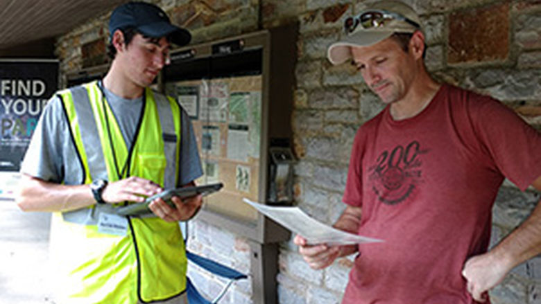 A member of the research team surveys a park visitor