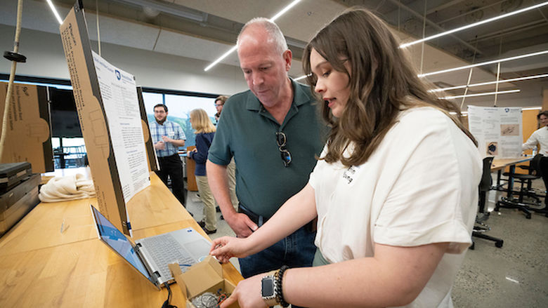 student and a adult looking at her computer screen