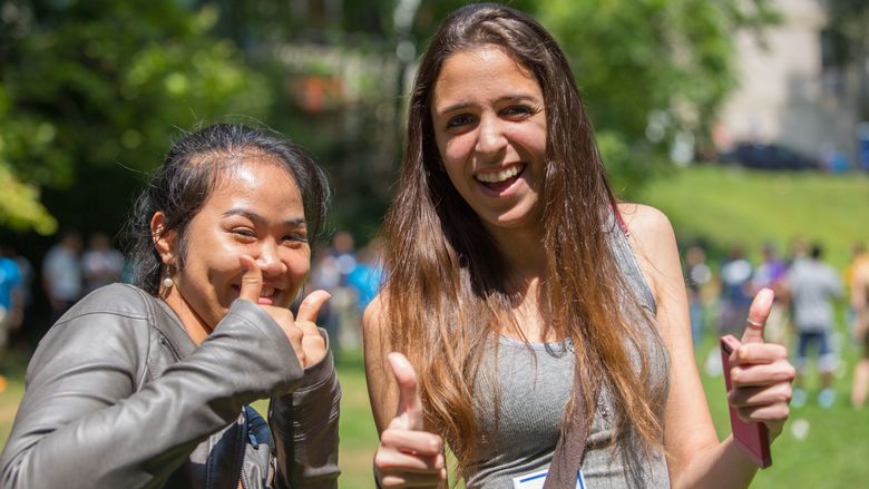 two female students giving thumbs up