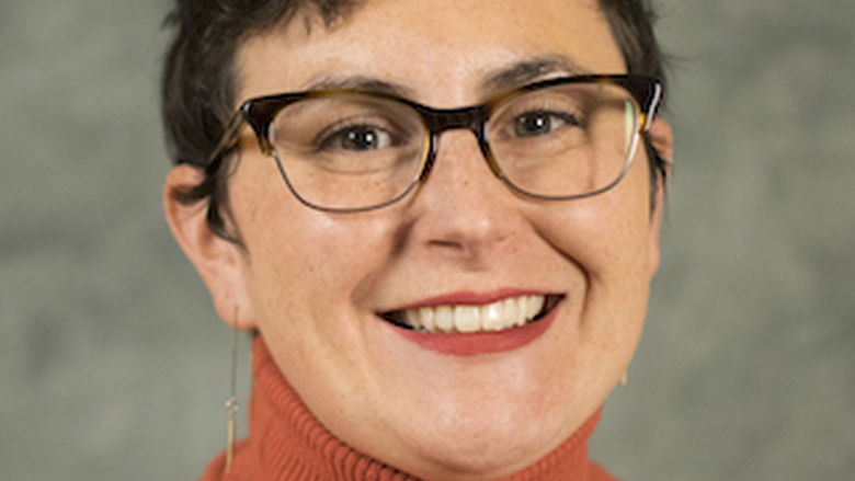 photo portrait of woman wearing black glasses and orange sweater