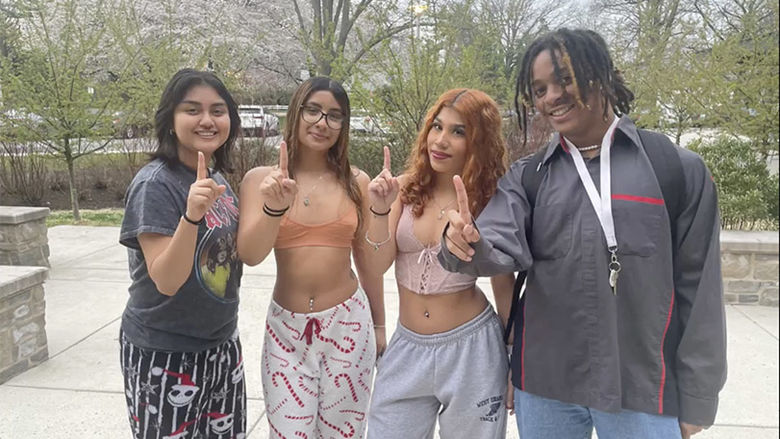 four students holding 1 finger up for "First Gen" students