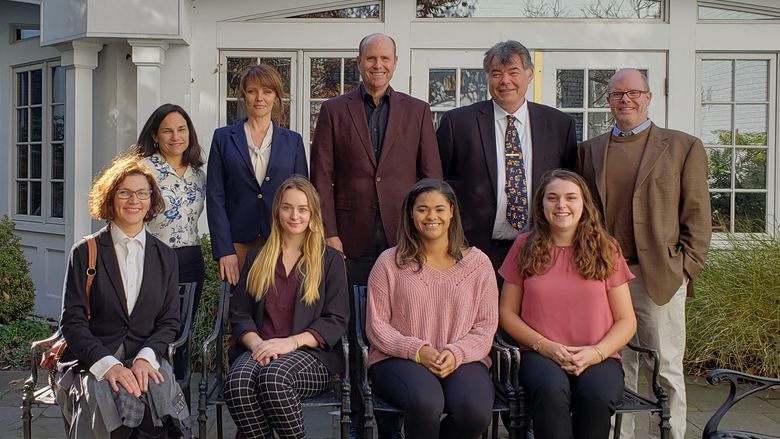 A group of nine faculty, staff, and students in front of the Nittany Lion Inn