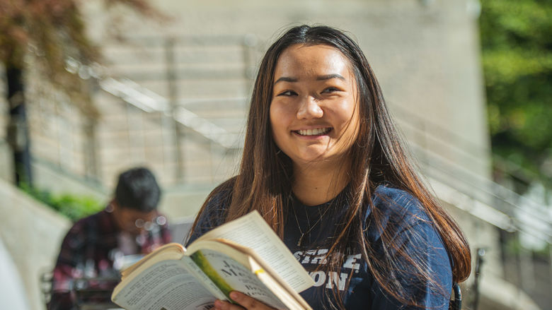 Student smiling with book