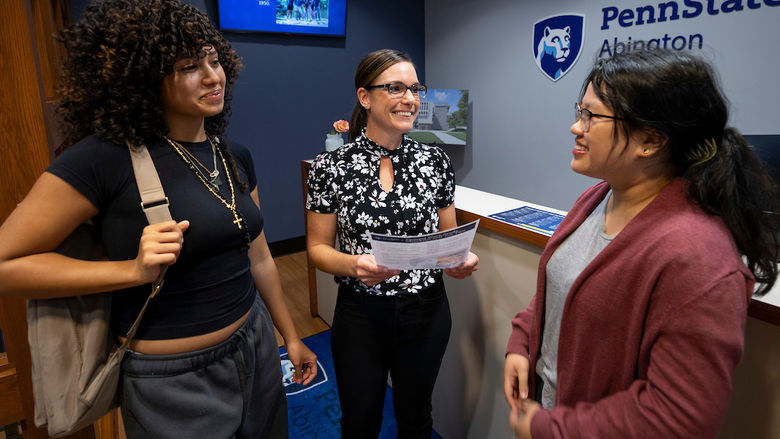 two students talking with financial aid staff 