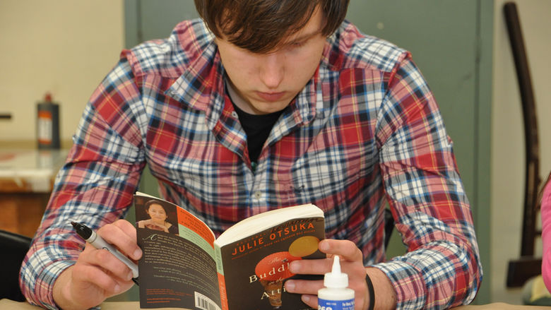 student reading 'Buddha in the Attic'