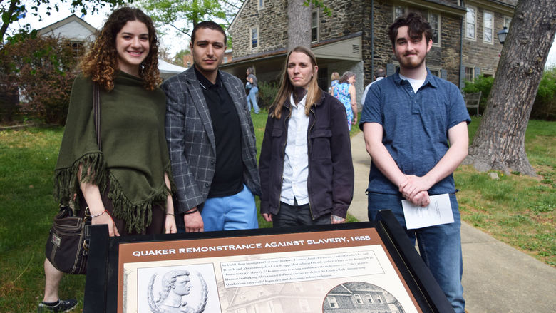 4 public history students standing in front of sign 