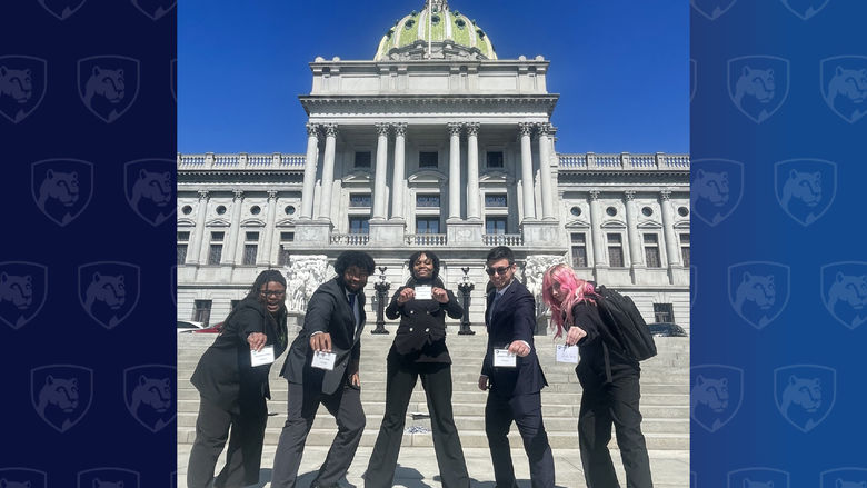 Five students stand in front of the Pennsylvania state capitol building